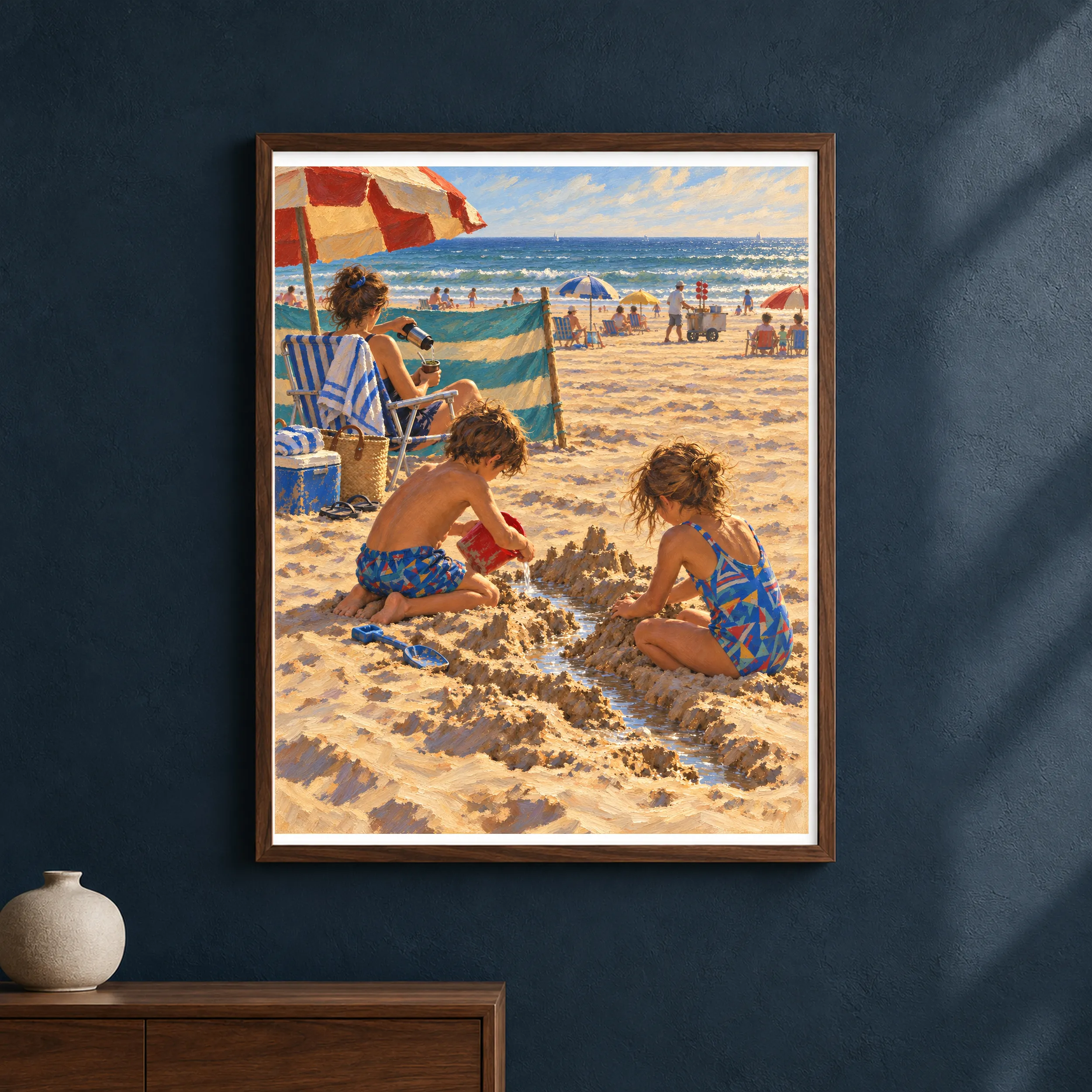 Framed vertical art print of two children building sand canals on an Argentine beach, displayed in a refined interior with the artwork as the main focus.