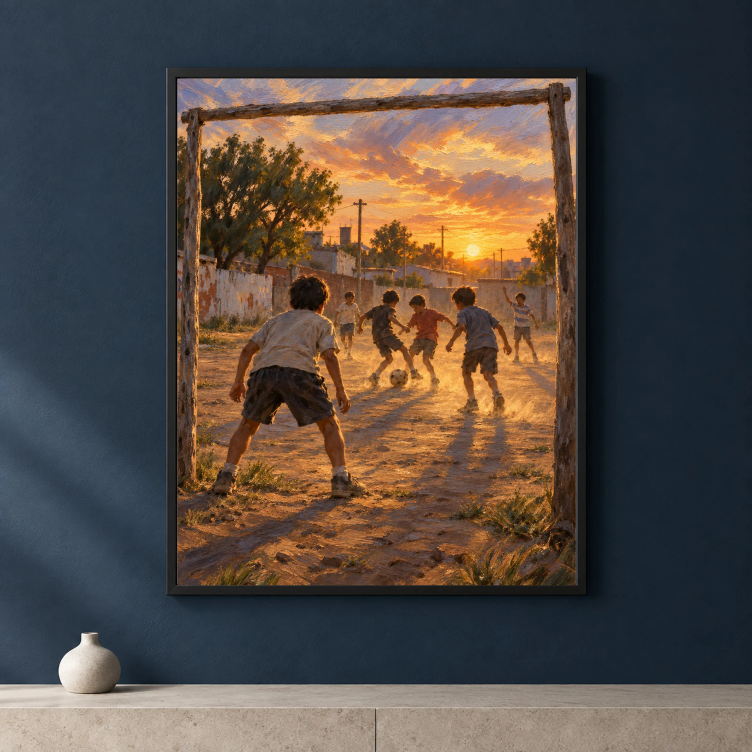 Framed print of children playing football on a dirt field at sunset hanging in a warm interior.